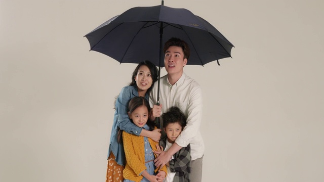 快乐的年轻家庭打着雨伞视频素材