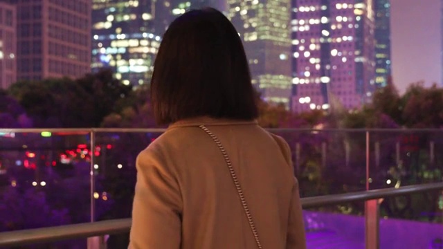 夜晚站在城市户外看风景和思考的孤独女人背影视频素材