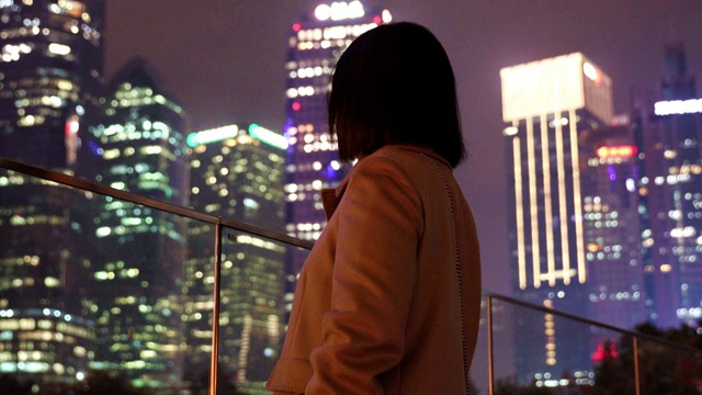 夜晚站在城市户外看风景和思考的孤独女人背影视频素材
