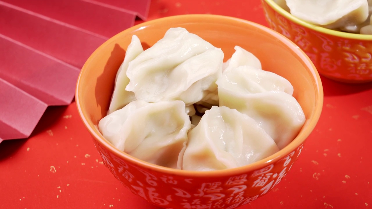 中华传统美食红色富贵喜庆金闪闪背景福字碗上的饺子视频素材