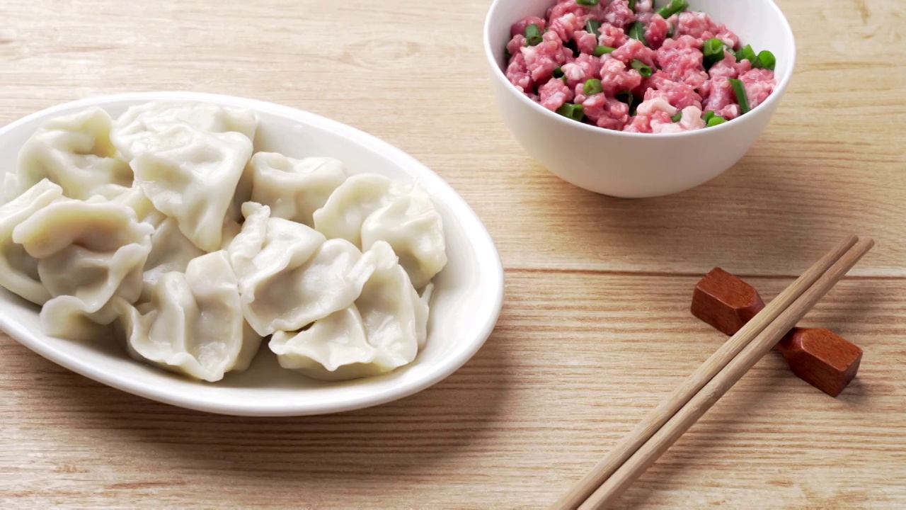 中国传统节日家里的味道低调清新木色背景上的一碟饺子和肉馅视频素材