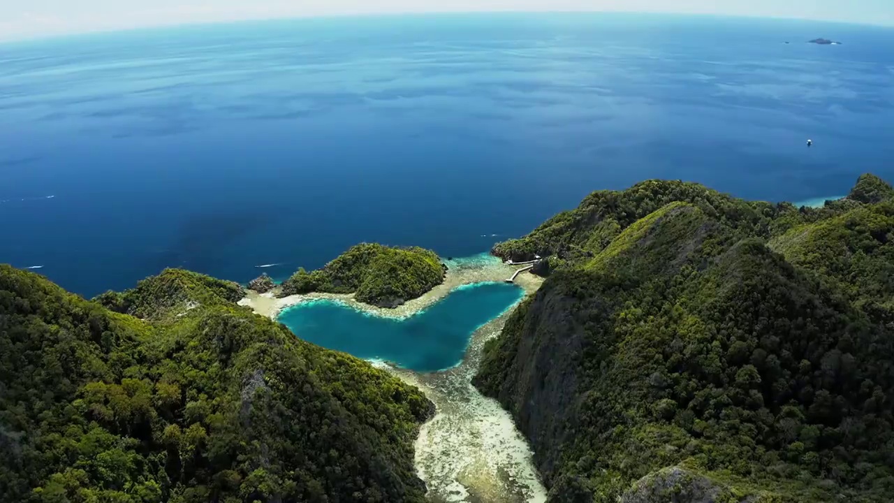 航拍蔚蓝海面上神奇的心形泄湖视频素材