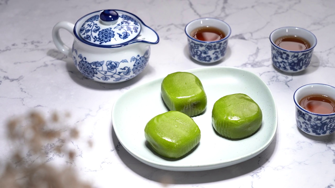 中国元素立春地道传统甜品盘子上的青团艾糍饼和青花瓷器茶水视频素材
