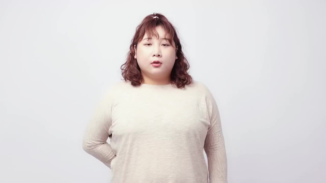 纯色背景里对着镜头说话的胖女孩视频素材