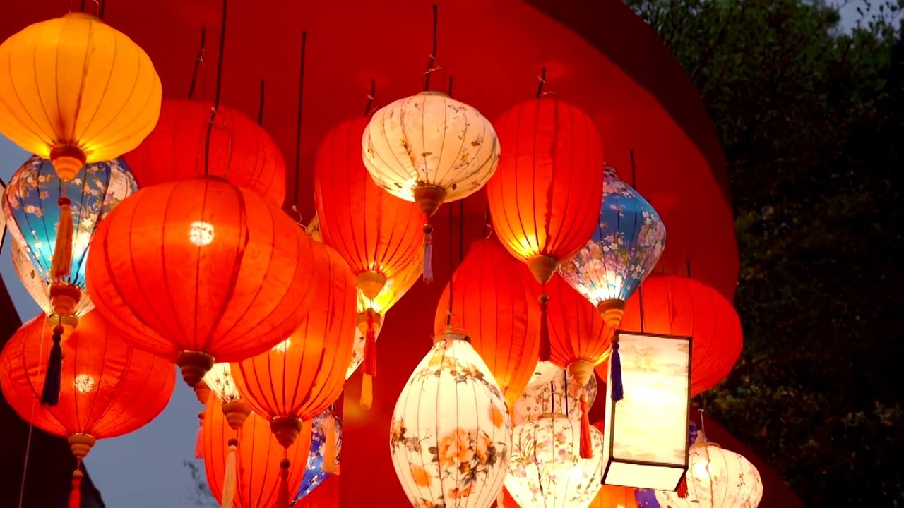 中国新年元宵中秋节傍晚户亮起了一片悬挂五颜六色的花艺装饰灯笼视频下载