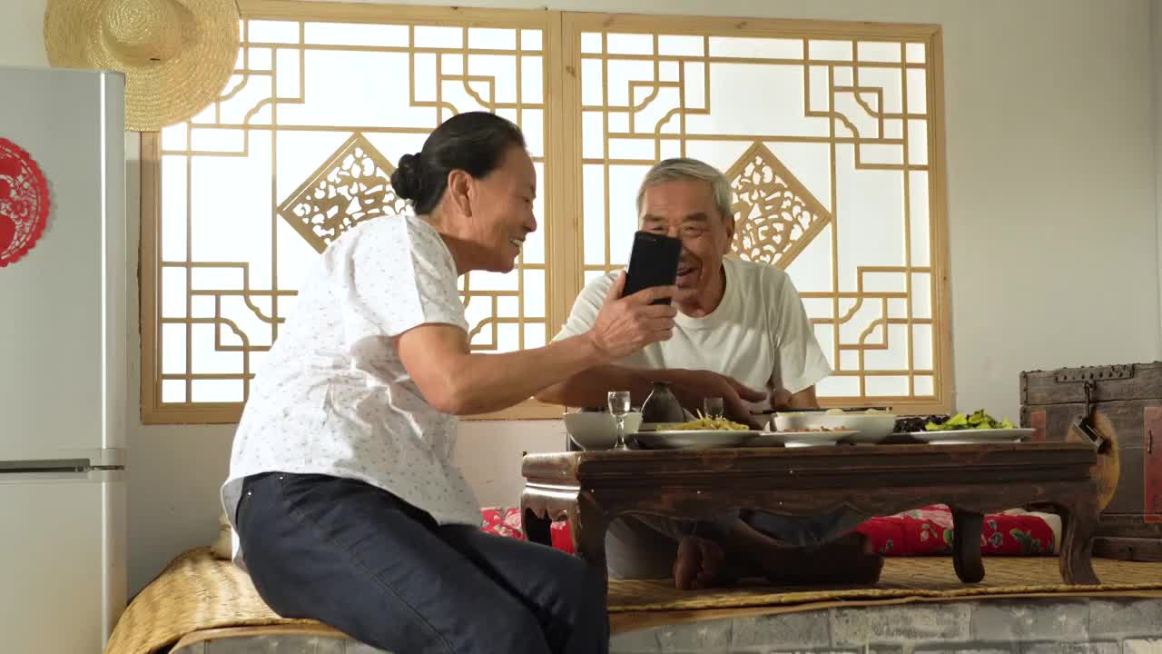 农民夫妇在家边吃饭边视频聊天视频素材