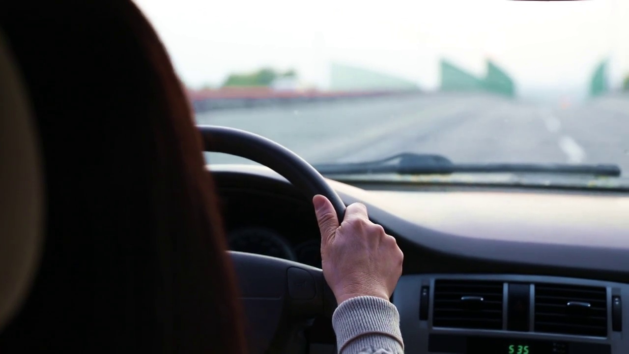 一个女人手握方向盘驾驶汽车特写视频素材