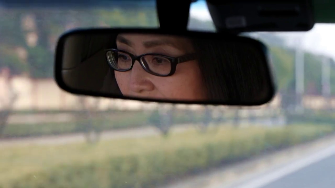 汽车后视镜中的一个女人在开车视频素材