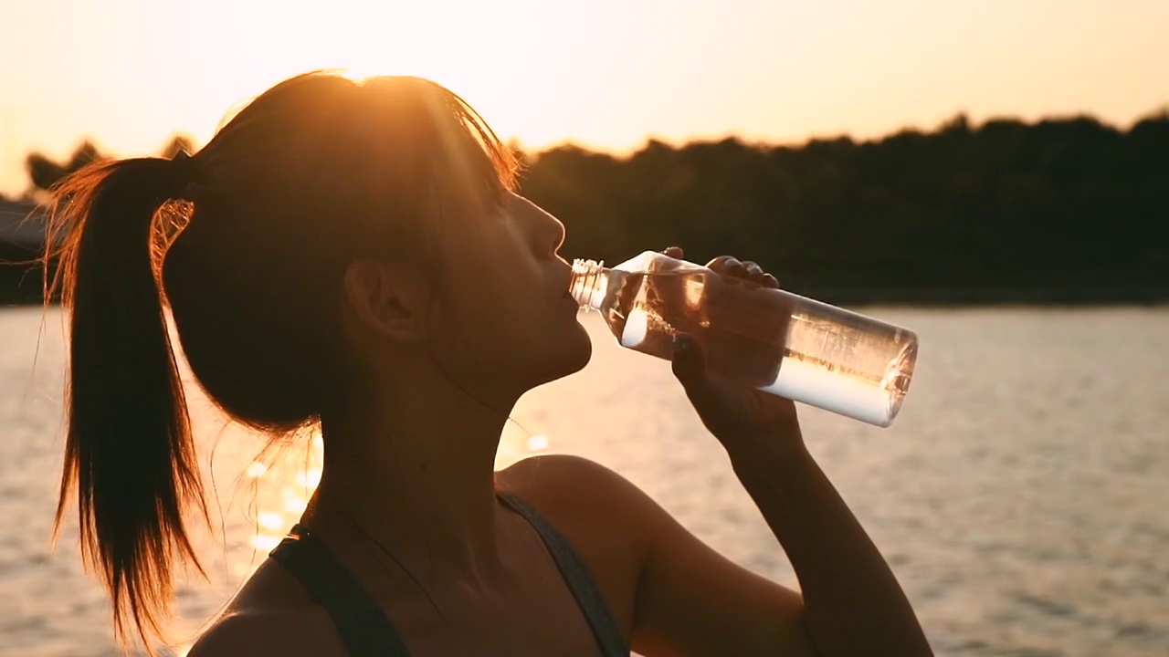 年轻女性在户外健身，喝水视频素材