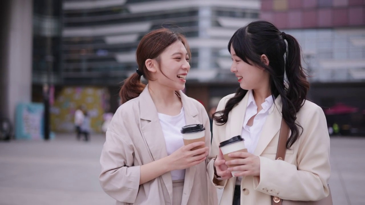 两个女孩在城市里边走边聊天视频素材