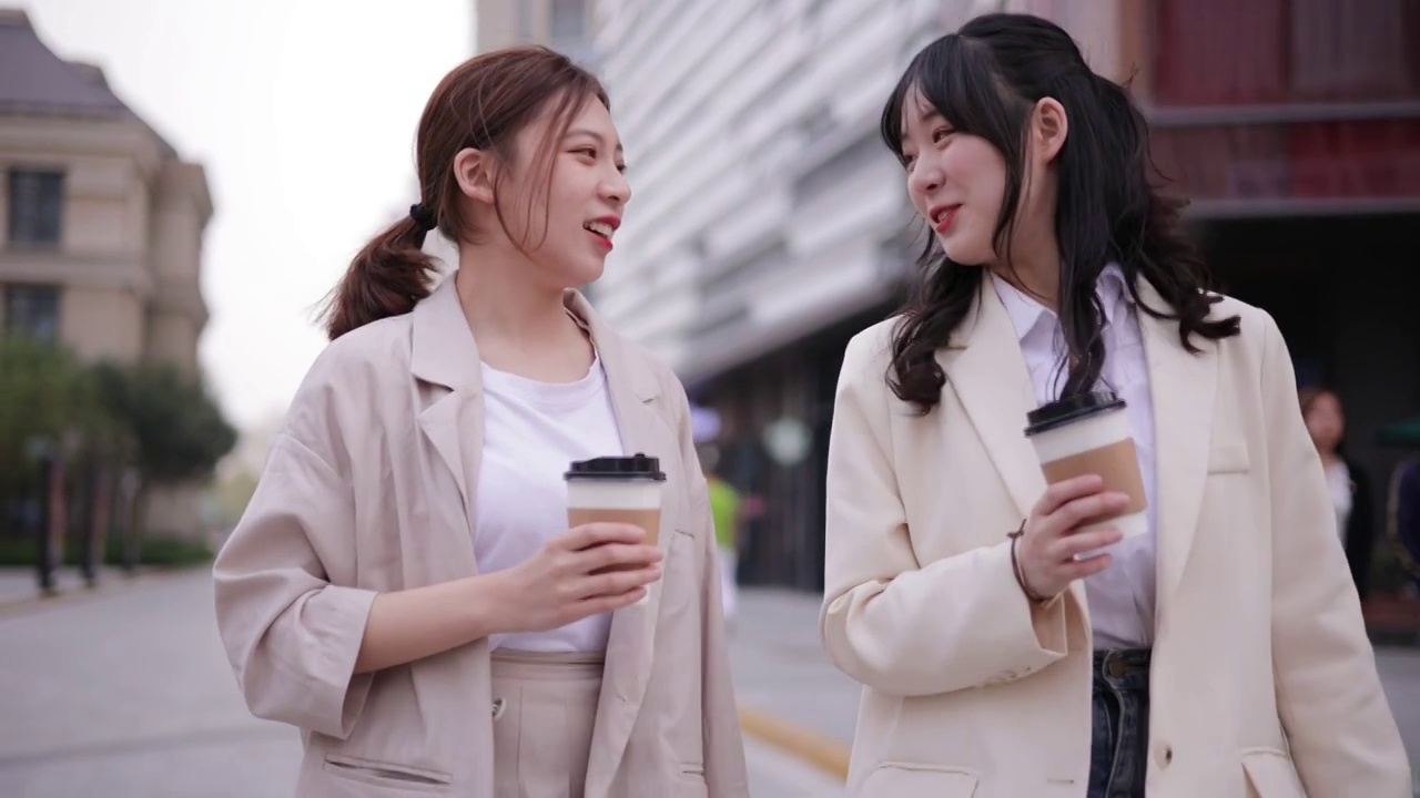 两个女孩在城市里边走边聊天视频素材