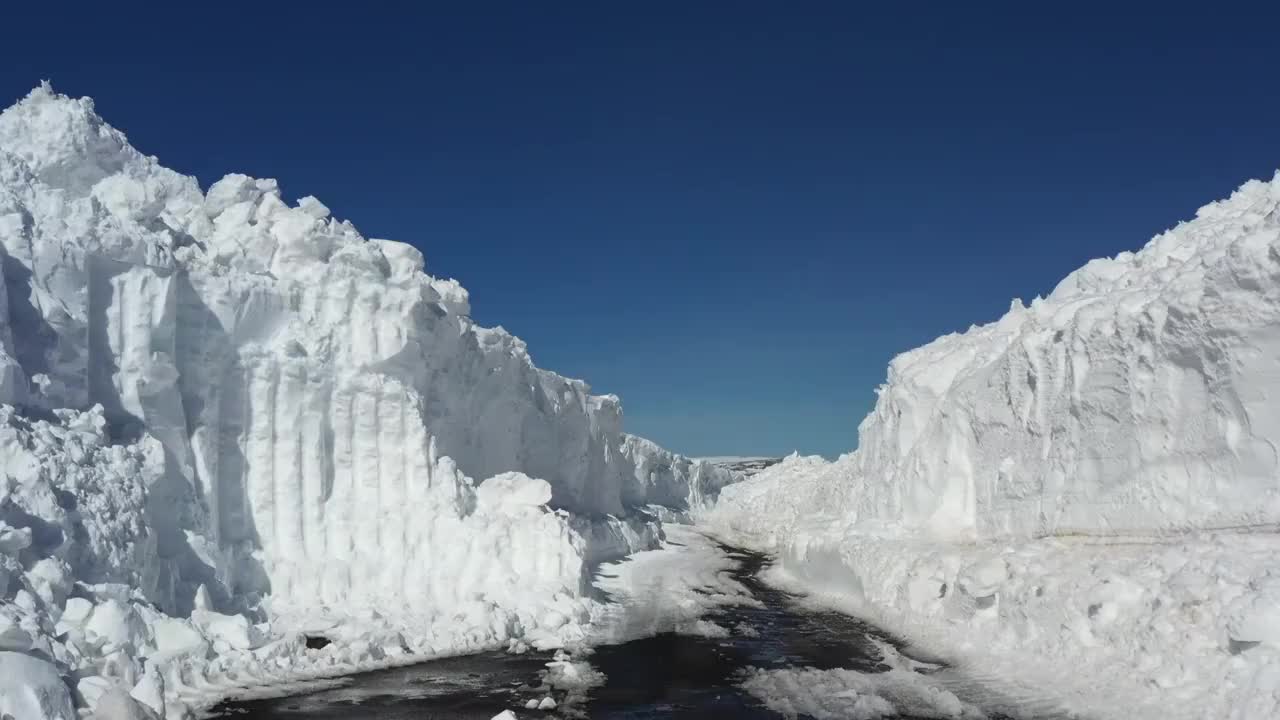 新疆塔城：航拍春天高山中的雪路视频下载