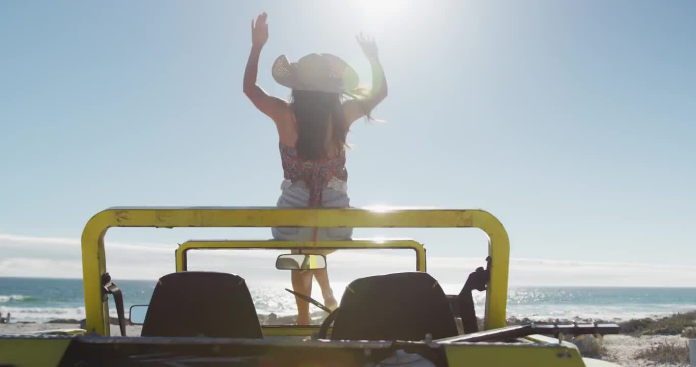 快乐的白人妇女坐在沙滩车在海边挥手视频下载