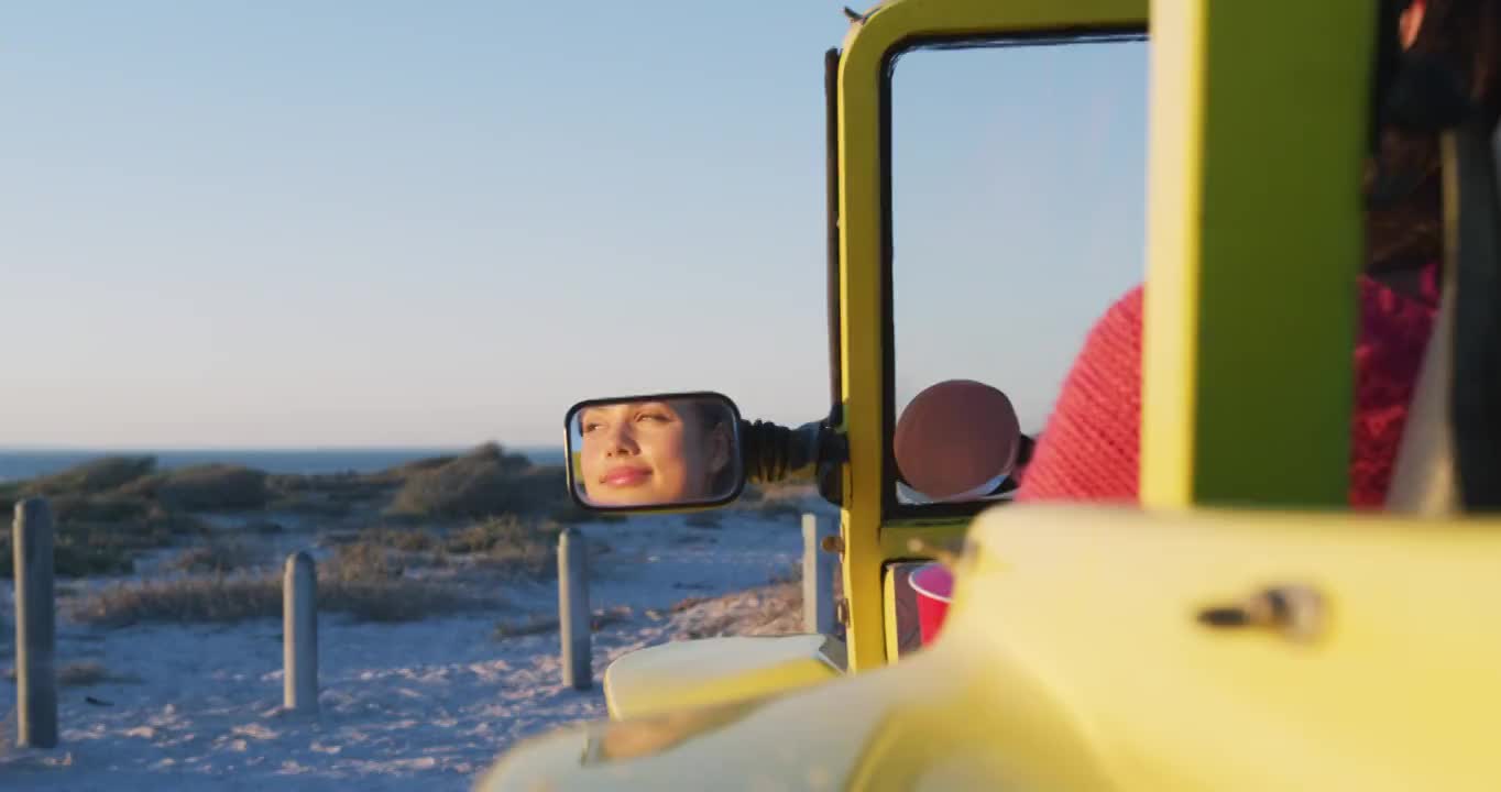 快乐的白人女人坐在沙滩车在海边喝视频素材