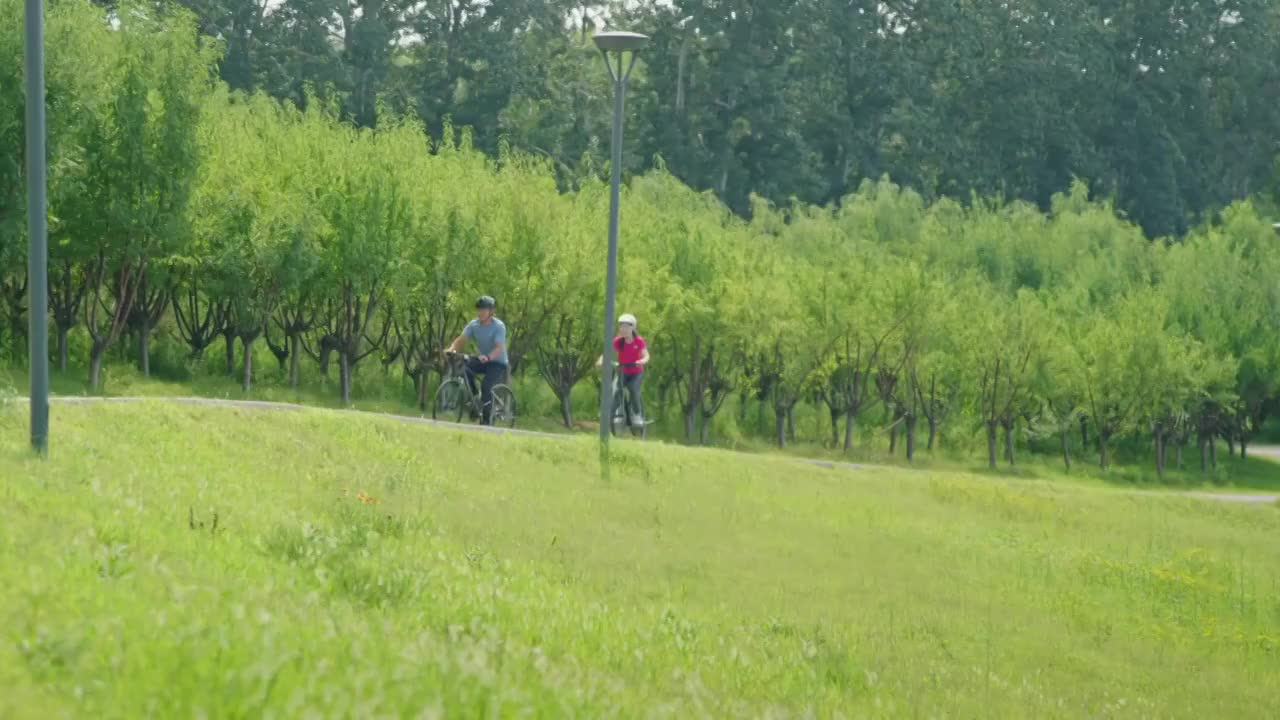 开心的中老年夫妇在公园骑自行车视频素材