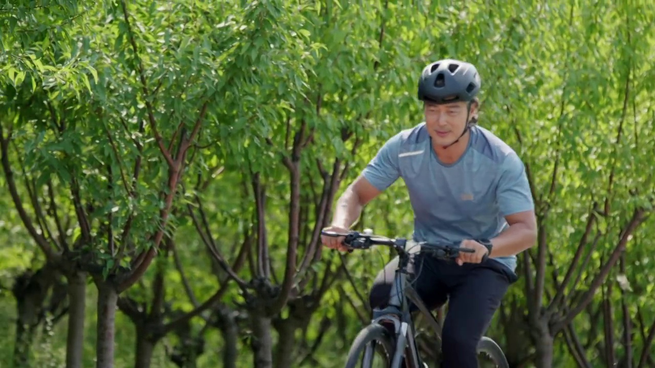 开心的中老年男子在公园骑自行车视频下载