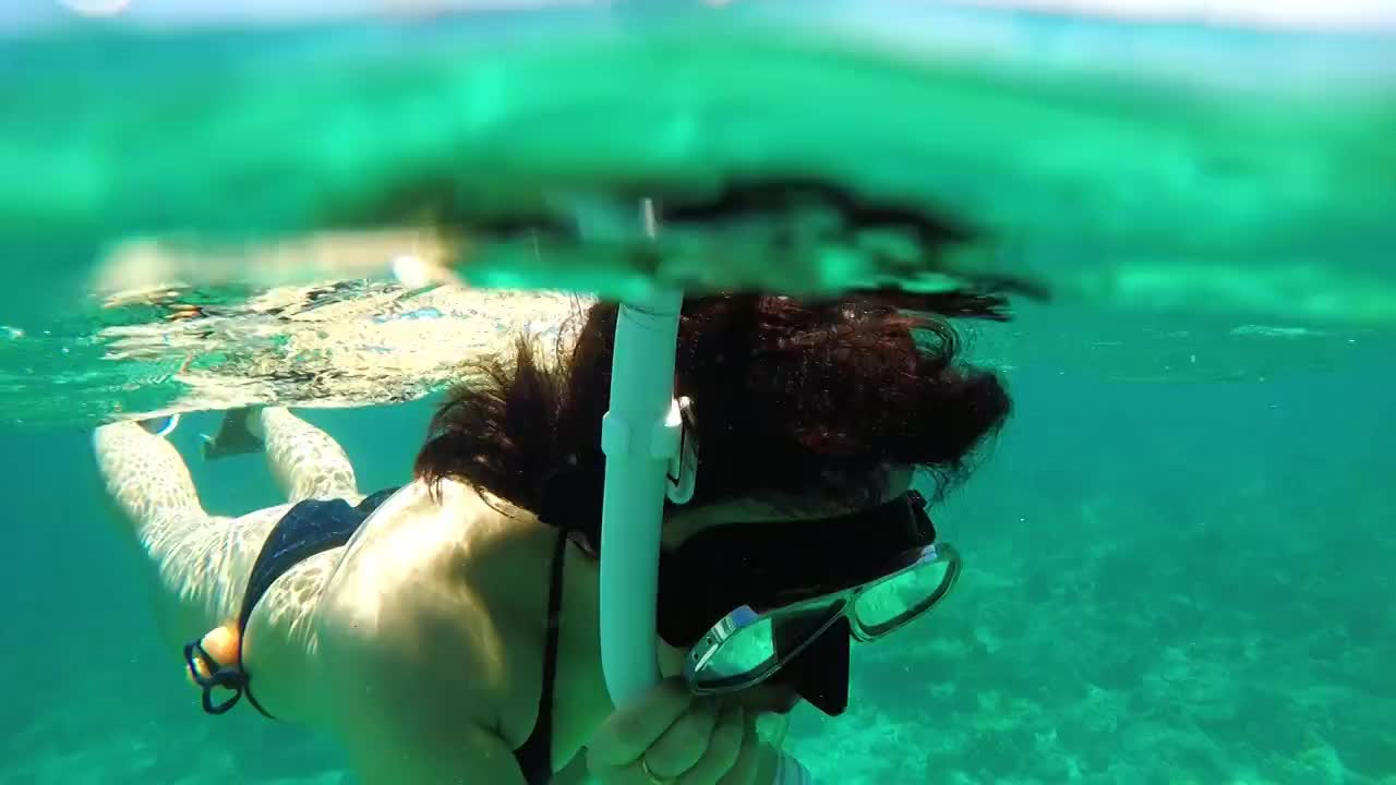一个穿着黑色泳衣正在浮潜的女人视频素材