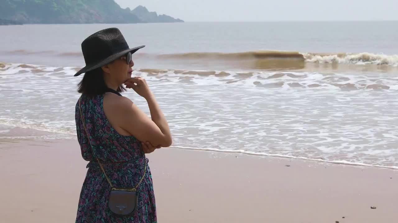一个时尚女人站在海边看风景视频素材