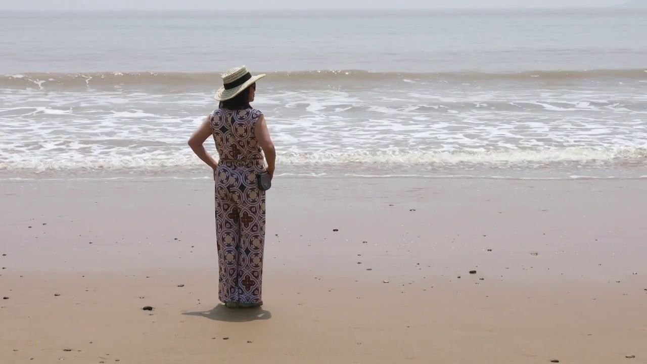 一个时尚女人站在海边看风景视频素材