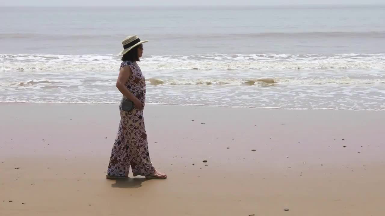 一个时尚女人在海边散步看风景视频素材