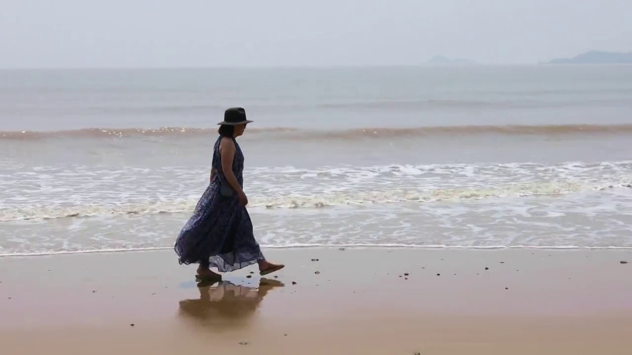 一个时尚女人在海边散步看风景视频素材