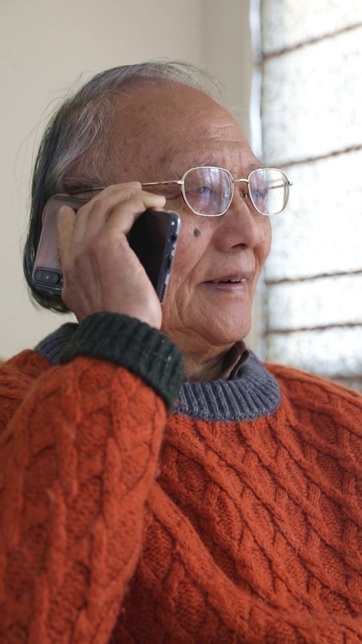 老年男人在家使用手机打电话视频素材