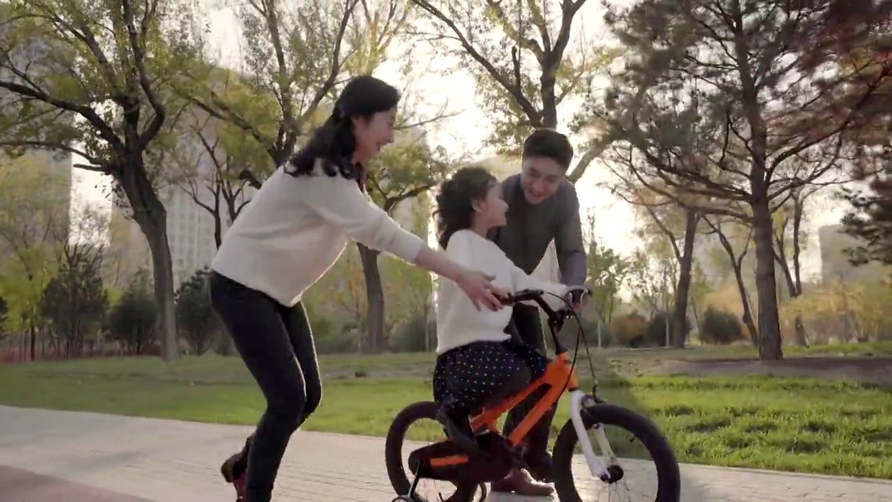父母教孩子骑自行车视频素材