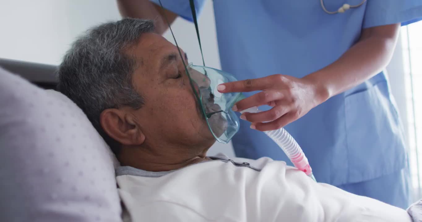 混血女医生协助家中卧床使用呼吸机的老人视频素材
