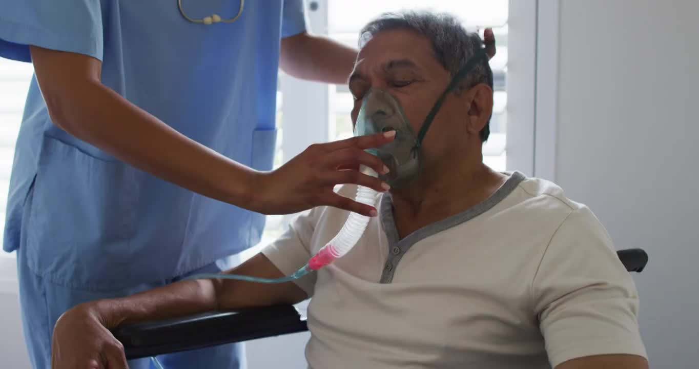 混血女医生在家中协助老年男子使用呼吸机视频素材