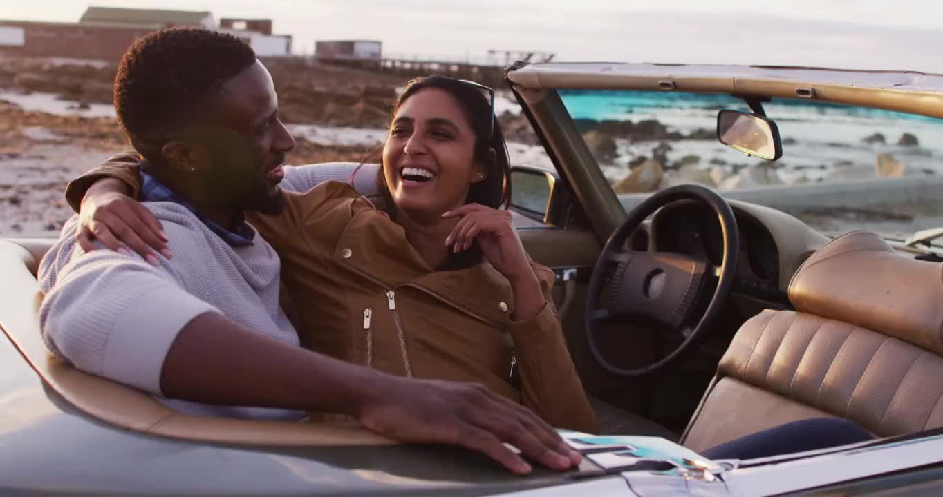 一对非洲裔美国夫妇坐在敞篷车里拥抱在一起视频下载
