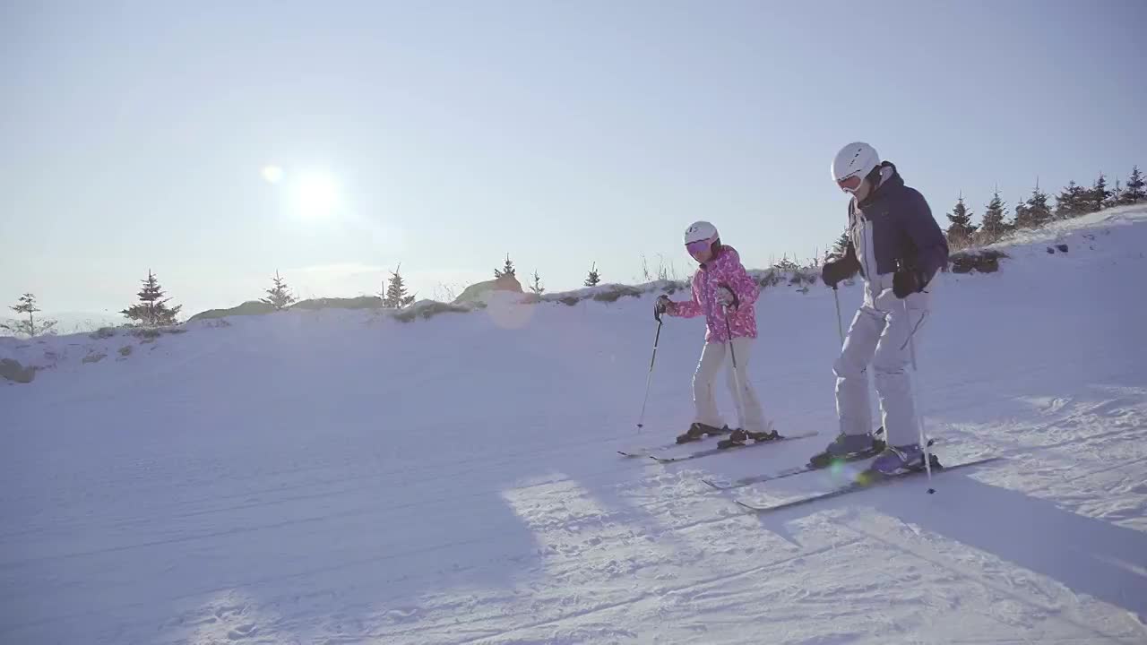 小女孩和爸爸在滑雪场滑雪视频素材