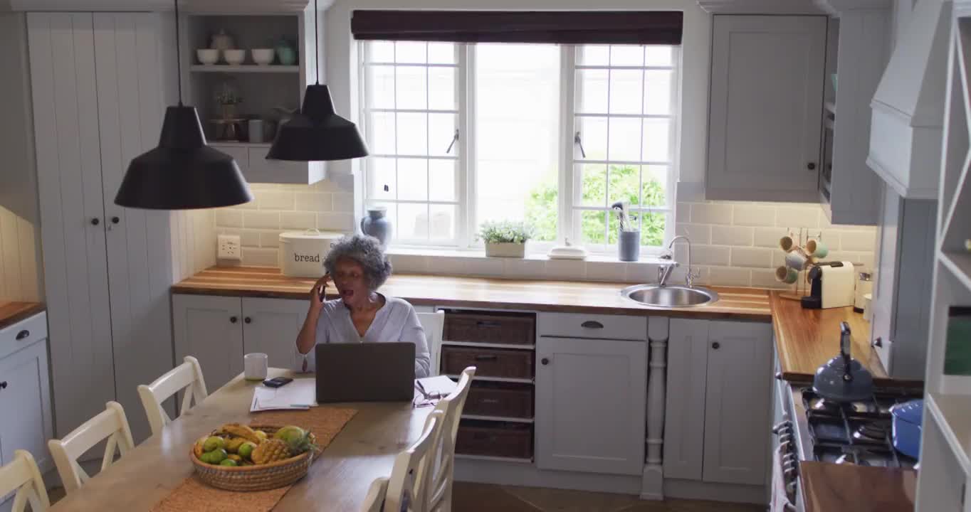 高级非洲裔美国女性在家里用笔记本电脑和智能手机聊天视频素材