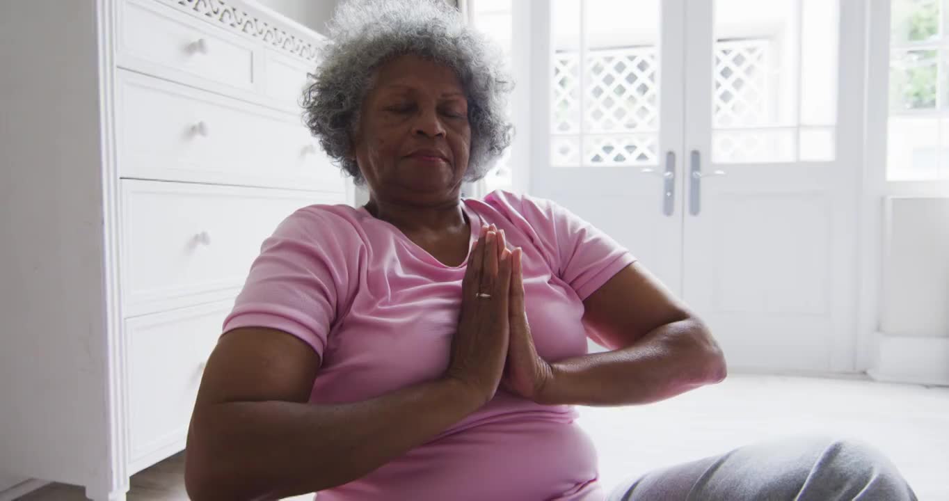 高级非洲裔美国妇女在家里的卧室里练习瑜伽视频素材