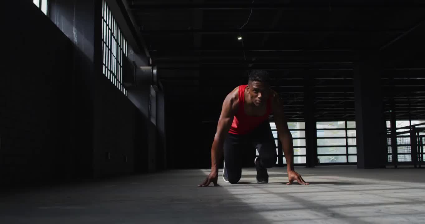 一个非裔美国人跪在一幢空房子里开始跑步视频素材