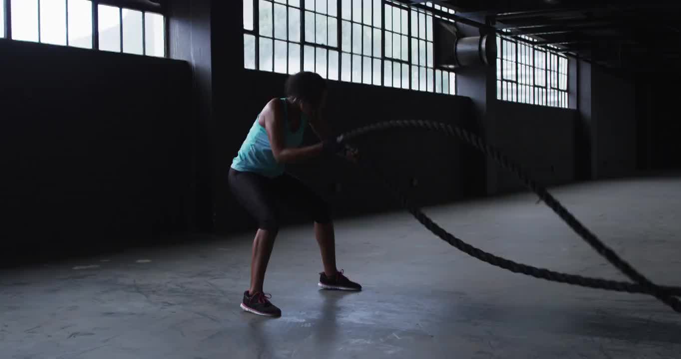 非裔美国妇女在一座空的城市建筑里练习格斗绳索视频素材
