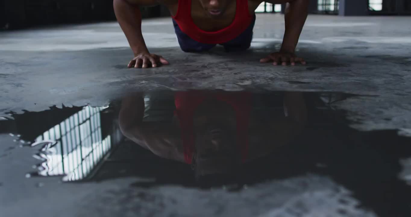 一个非裔美国人在一座空的城市建筑里做俯卧撑视频素材