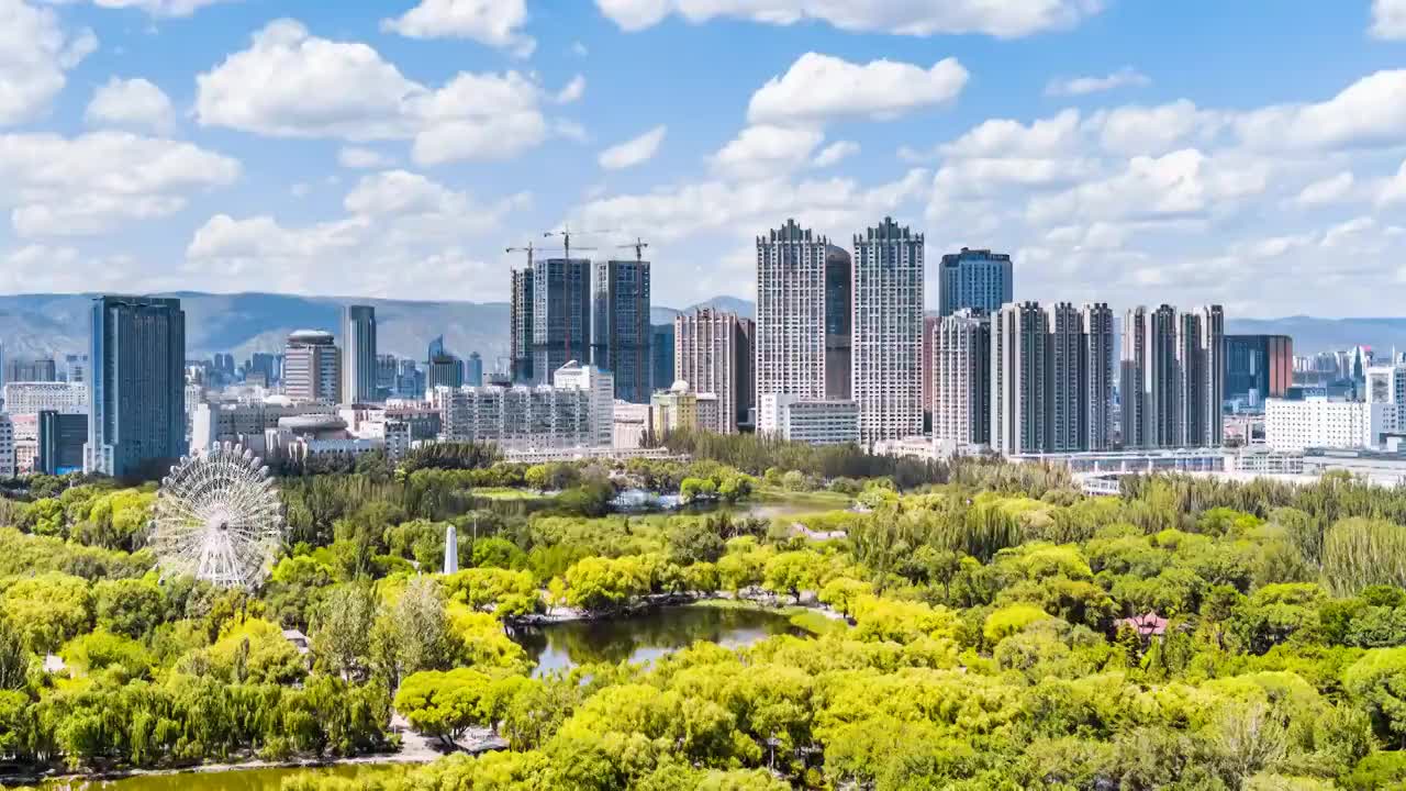 中国内蒙古呼和浩特青城公园摩天轮和城市天际线风光延时摄影视频素材