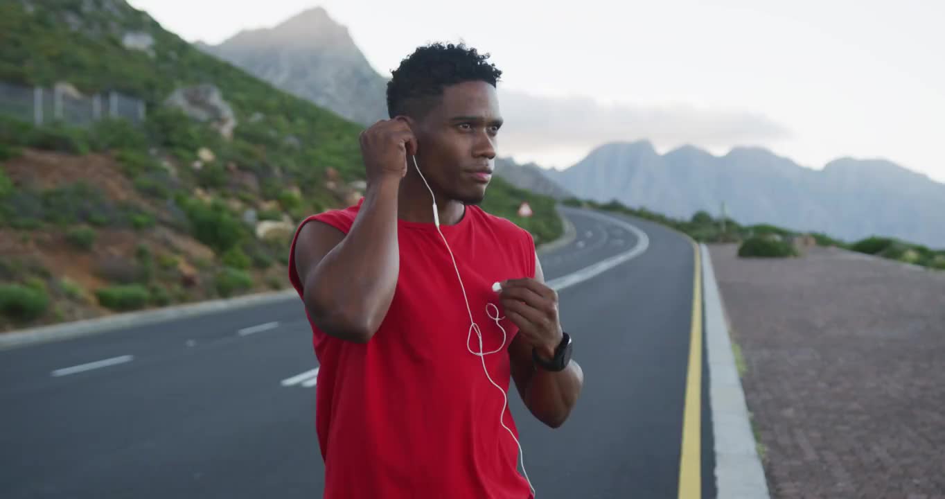一个非裔美国人站在路上戴着耳机视频素材