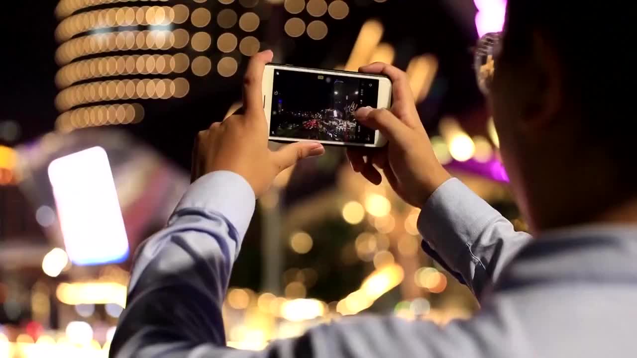广西南宁市行人用手机记录建党百年灯光秀视频素材