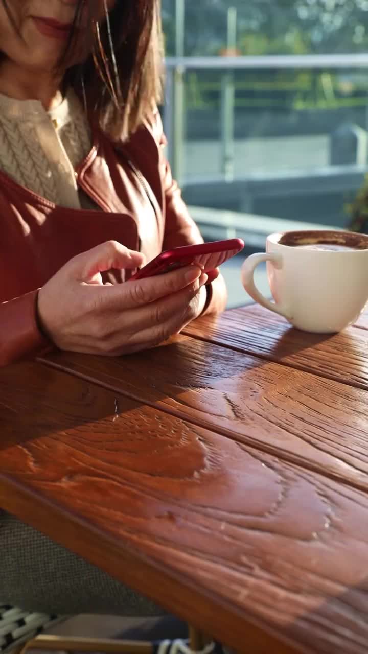 一个女人在咖啡馆使用智能手机视频素材