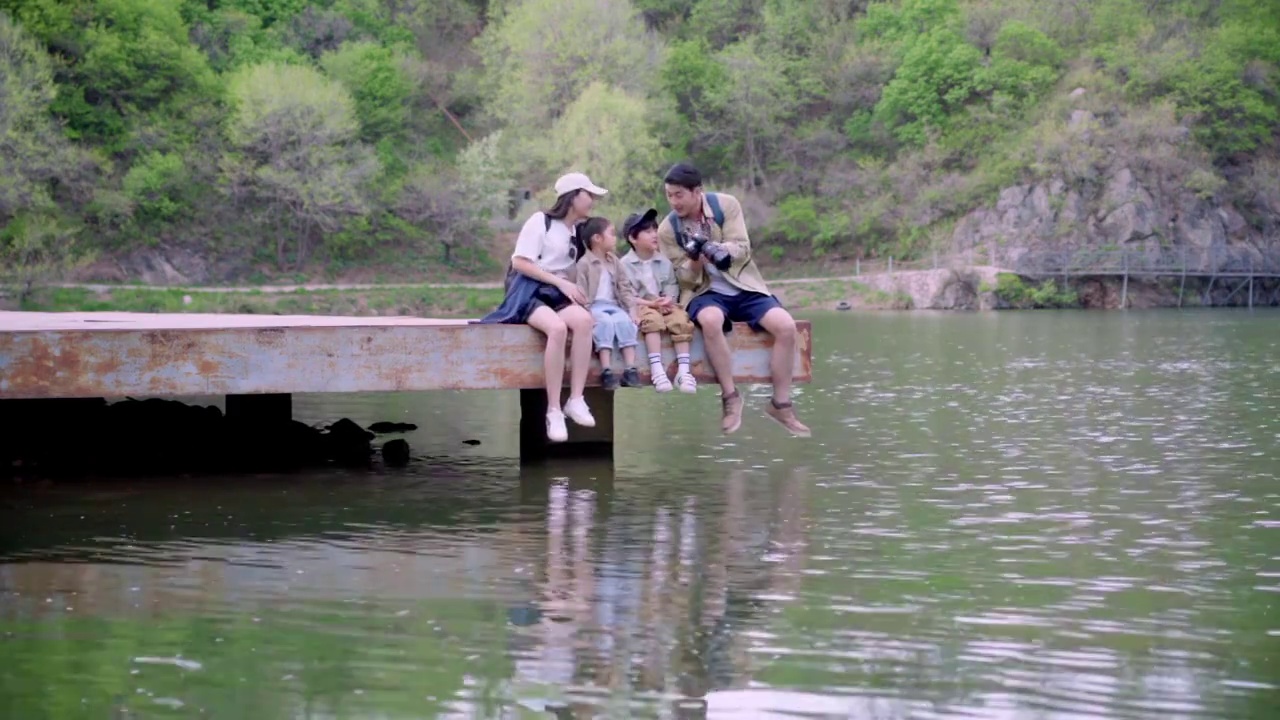 快乐家庭坐在湖边玩耍视频素材