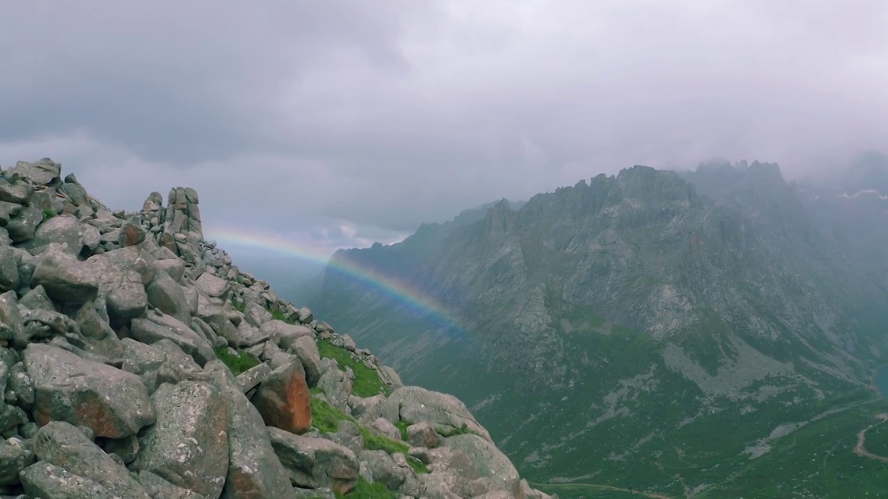 雨中沿着山边航拍山谷彩虹视频素材