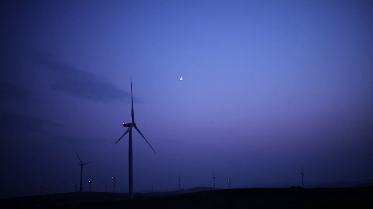 风车发电新能源与傍晚月落美景视频素材