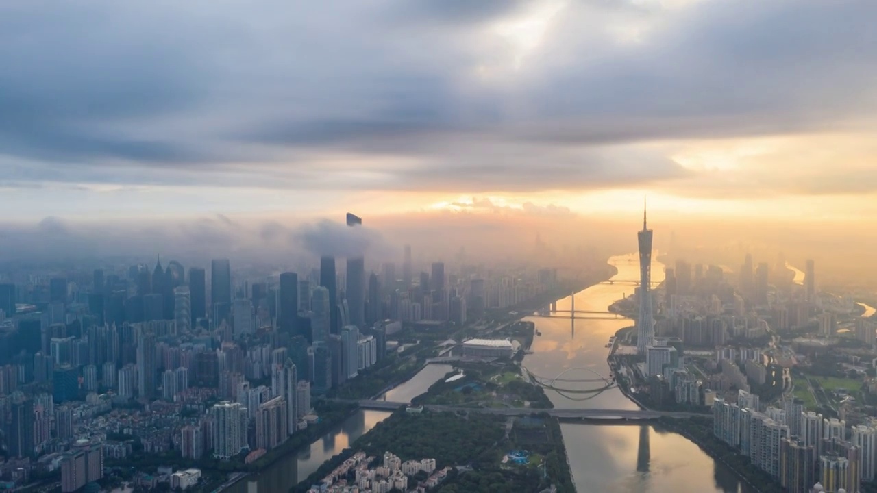 日出时分的广州天空云雾弥漫，金色阳光冲破云层洒在珠江及其两岸视频素材