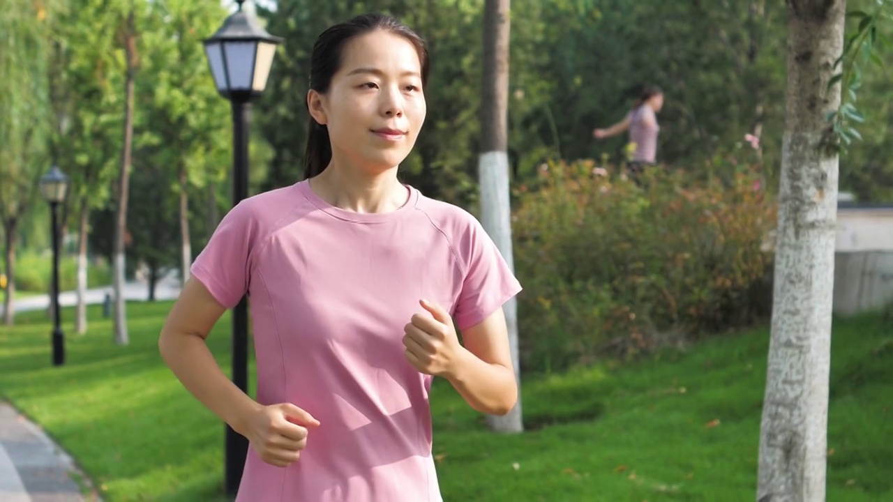 升格视频亚洲中国女性女士带耳机晨跑跑步运动视频素材