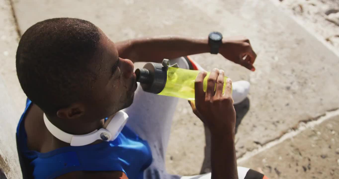 非裔美国人在户外运动时坐着喝水视频素材