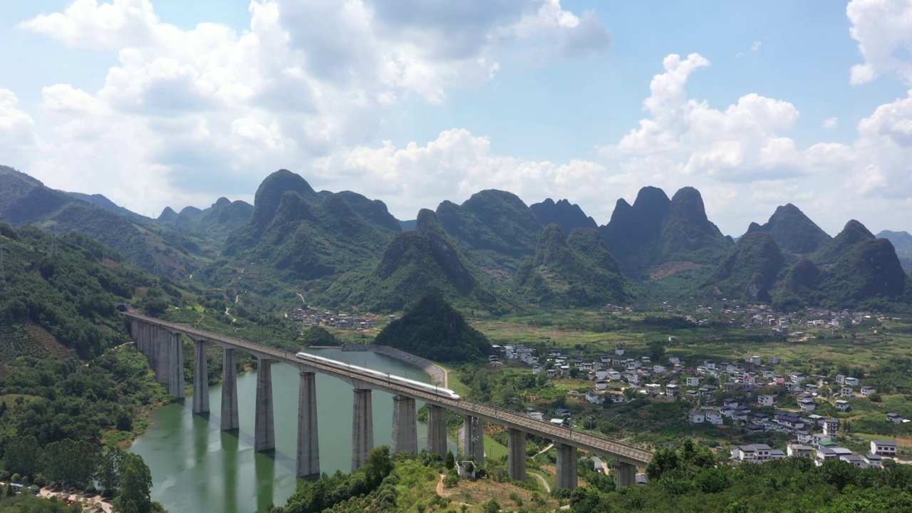 蓝天白云下桂林阳朔群山间高架桥上行驶的高速列车视频素材
