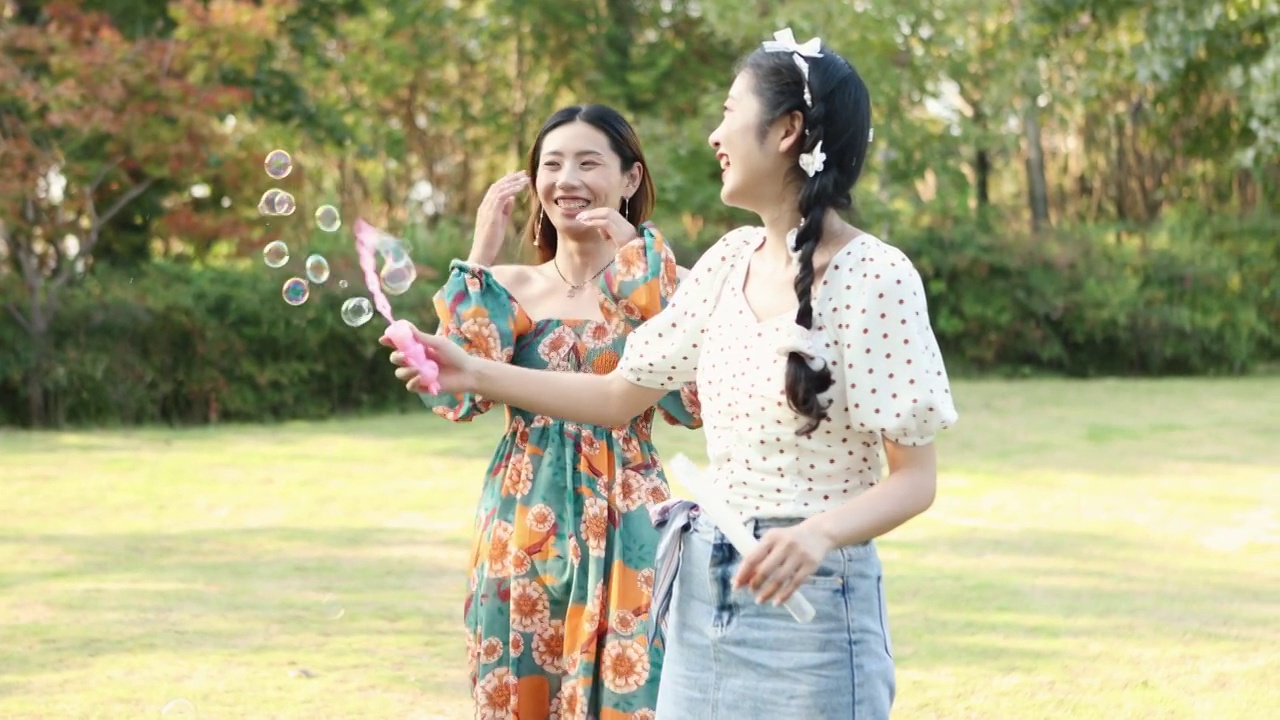 两个亚洲闺蜜在户外露营野餐玩耍吹泡泡视频素材