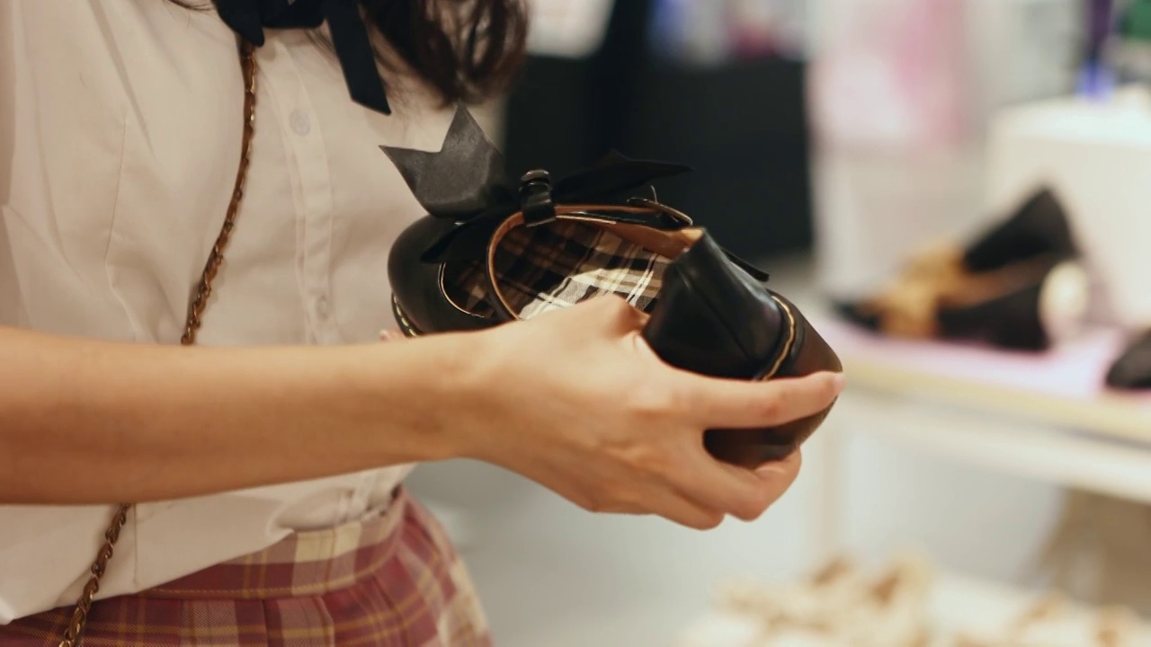 一个亚洲人美女在挑选鞋子视频素材
