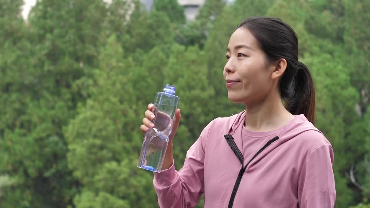 亚洲中国人女性在户外森林大自然喝水饮用水视频素材